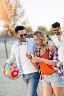 Gençlerin grup eğleniyor kumsalda yaz tatili sırasında mutlu