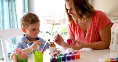 Mutlu aile boyama Paskalya yumurtaları mutfak masasında