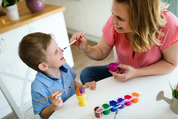Aile, anne ve oğlu eğlenceli sahip boya ve yumurta tatil için süsleyin