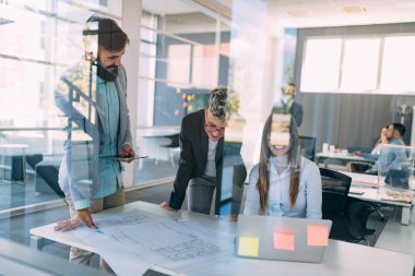 Bir grup mimar ve iş adamı birlikte çalışıyor ve beyin fırtınası yapıyorlar.