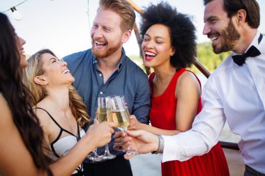 Bir grup arkadaş parti yapıyor ve içki içiyor. İçkili mutlu gençler.