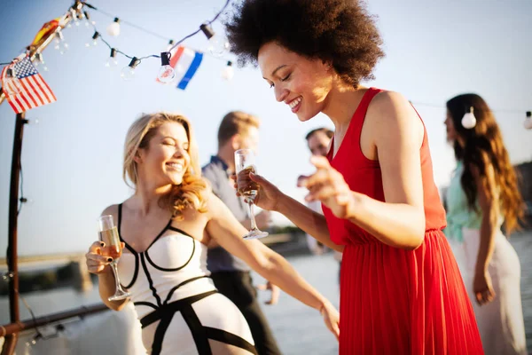 Group of happy friends at party dancing and smiling together