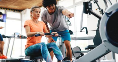 Kişisel antrenör yardımcı kadın kilo içinde jimnastik salonu