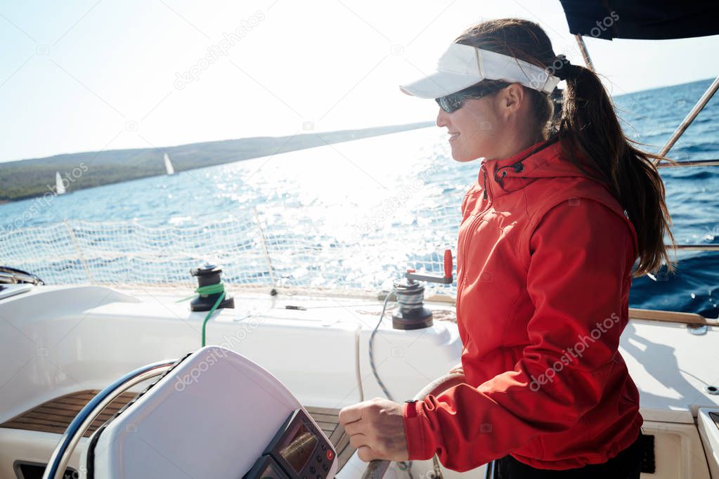 Attractive strong woman sailing with her sail boat