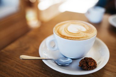 Masada bir fincan kahve, latte kahve sanatı