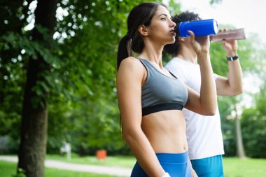 Atletik mutlu çift arkadaş içme suyu çalıştırdıktan sonra