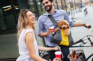 Köpek ile şehirde güneşli bir günde bir bisiklet binmek genç çift