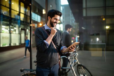 Şehirde bir dijital tablet üzerinden online genç yakışıklı adam