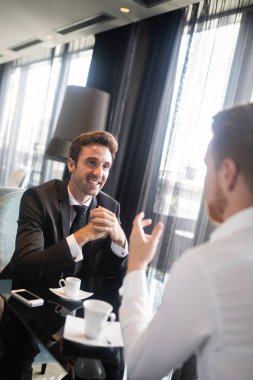Yakışıklı iki genç iş adamının kafede bir toplantısı var.