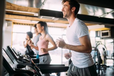 Fitness spor kulübünde koşu bandıüzerinde çalışan sağlıklı uyum insanlar