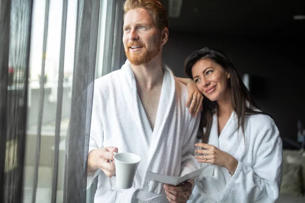 Fiatal pár, fürdőköpeny, átfogó, és keres el a wellness-központ — Stock Fotó