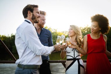 Bir grup arkadaş parti yapıyor ve içki içiyor. İçkili mutlu gençler.