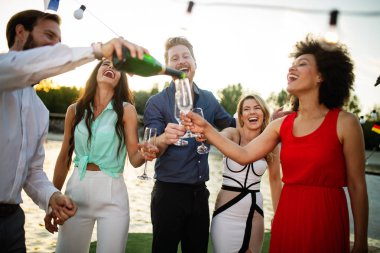 Bir grup mutlu insan ya da arkadaş partide eğleniyor ve gülümsüyor.