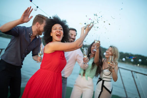 Group of happy friends at party dancing and smiling together