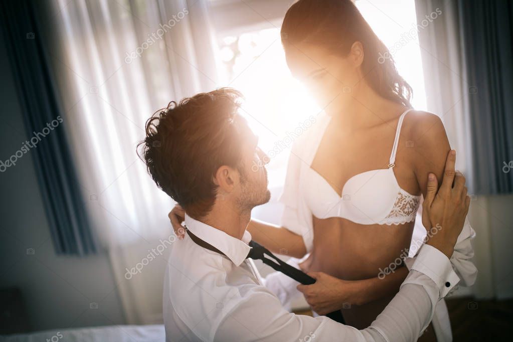 Attractive sensual couple sharing intimate moments in bedroom