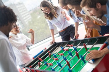 İş arkadaşları masa futbolu oynuyor ve işten izin alıp dalga geçiyorlar.