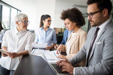 İş yerinde tam konsantrasyon. Ofis masasında birlikte çalışan ve iletişim kuran iş adamları grubu