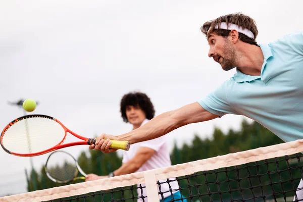 Group of fit friends at the club playing tennis