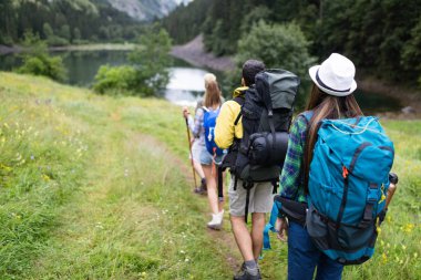 Gün batımında bir dağa yürüyen yürüyüşçüler ve arkadaşlar grubu