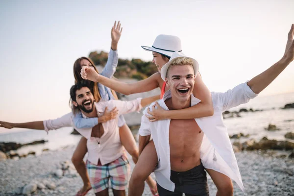 Group of excited happy young friends having fun together at he beach