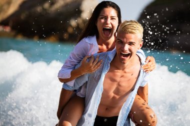 Mutlu romantik çift kumsalda eğleniyor ve sevişiyor.