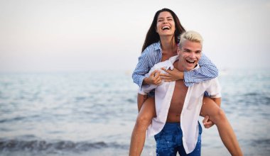 Mutlu romantik çift güneşli bir günde sahilde eğleniyor.