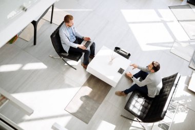 Ofis lobisinde fikirleri tartışmak iş adamları