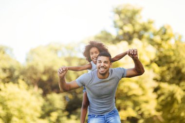 Genç Baba kızını doğada sırtında taşıyan portresi