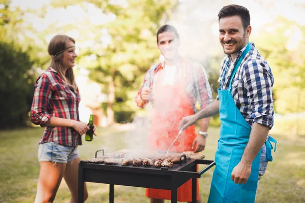 Amigos felizes desfrutando de churrasco — Fotografia de Stock