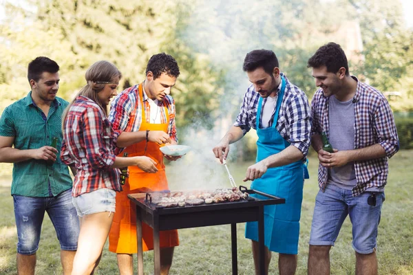 Venner som nyter grillfest – stockfoto