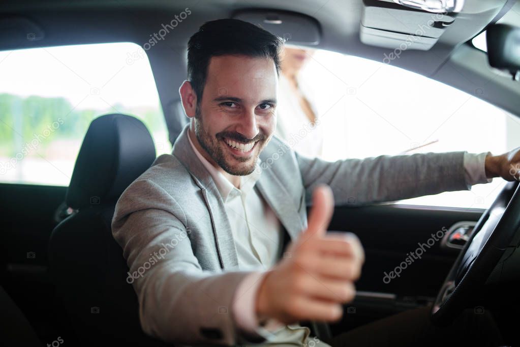 Portrait of happy young customer buying new car