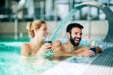 Mutlu çekici çift rahatlatıcı yüzme havuzunda