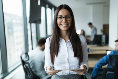 Modern ofiste dijital tablet kullanan çekici bir iş kadını