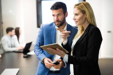 İş adamları ofiste dijital tablet kullanırken tartışıyor