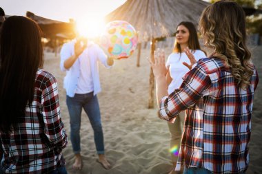 Gençlerin grup eğleniyor kumsalda yaz tatili sırasında mutlu