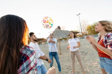 Gençlerin grup eğleniyor kumsalda yaz tatili sırasında mutlu