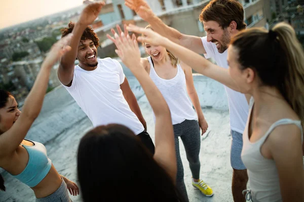 Grupo de amigos felizes em forma exercitando ao ar livre na cidade — Fotografia de Stock