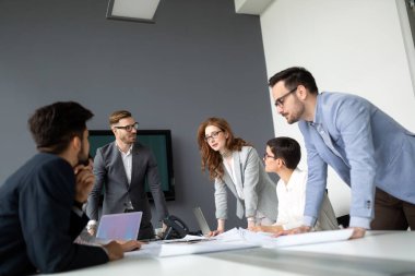 Bir grup mimar ve iş adamı birlikte çalışıyor ve beyin fırtınası yapıyorlar.