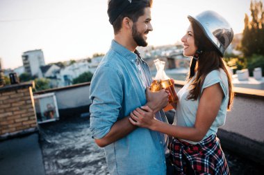 Gün batımında çatı katında bir içecek yaparken flört Çift