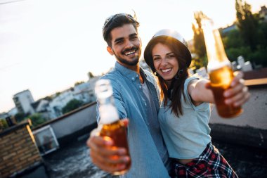 Gün batımında çatı katında bir içecek yaparken flört Çift