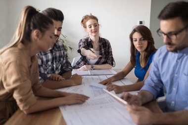 İş ortaklarının toplantıda belge ve fikirleri tartıştığı resim