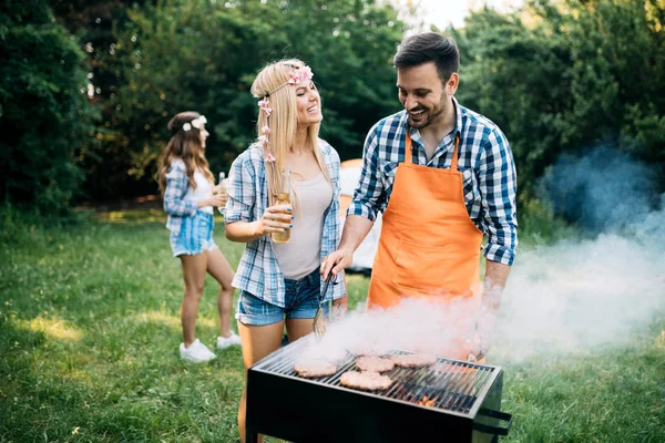 バーベキューパーティーを楽しむ楽しいグリル肉を持っている友人 — ストック写真