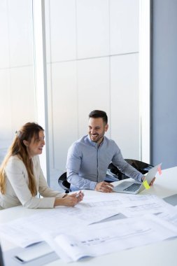 Takım inşaat planları üzerinde birlikte çalışan mimarlar