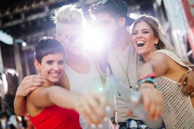 Mutlu genç arkadaşlar müzik festivalinde eğleniyor.