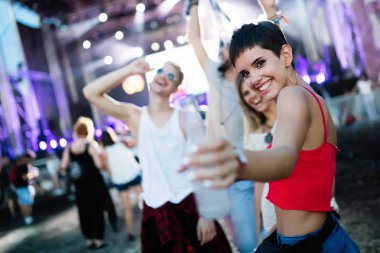 Mutlu genç arkadaşlar müzik festivalinde eğleniyor.