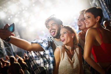 Mutlu genç arkadaşlar müzik festivalinde eğleniyor.