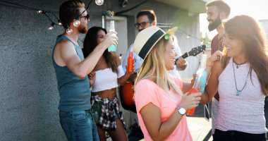 Grup arkadaşıyla birlikte eğleniyor. Çatı partide eğleniyor arkadaşlar.