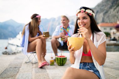 Bir grup mutlu arkadaş sahilde eğleniyor ve eğleniyorlar.