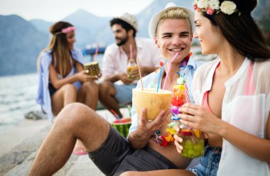 Bir grup arkadaş sahilde dans edip eğleniyorlar. Plajda yaz tatili partisi