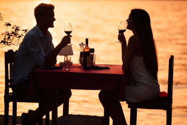 İnsanlar, tatil, aşk ve romantizm kavramı. Genç çift sahilde romantik bir akşam yemeği zevk.